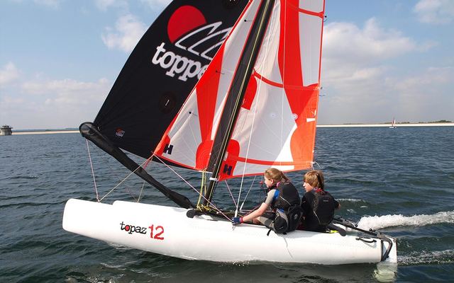 Catamarán Topaz 12 con gennaker negro y dos tripulantes